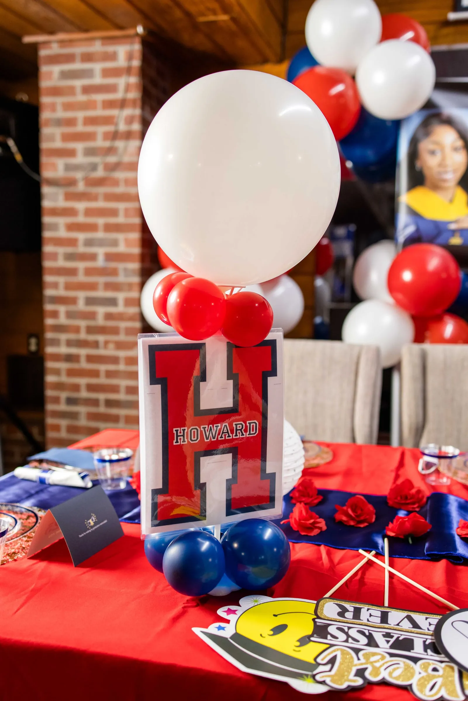 Red, white and blue balloons over a Howard letter sign on a graduation party table.