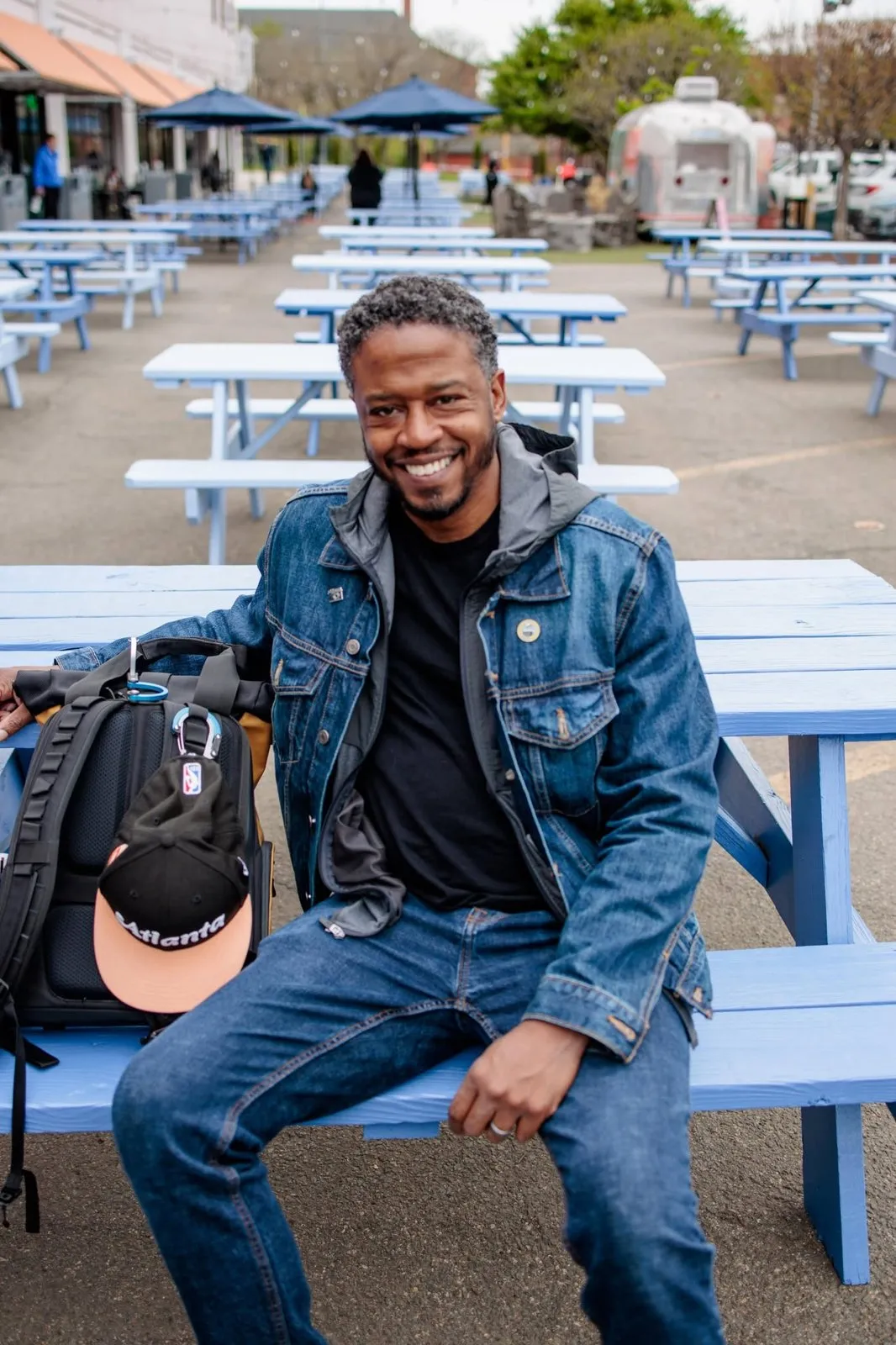 Daniel Lee seated at a picnic table with his camera bag